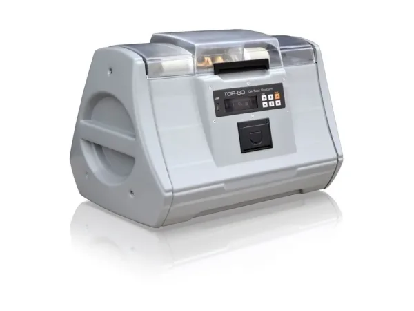 Equipo GlobalCore TOR-80 para medir la tensión de ruptura de aceite de transformador, con carcasa gris y tapa transparente.